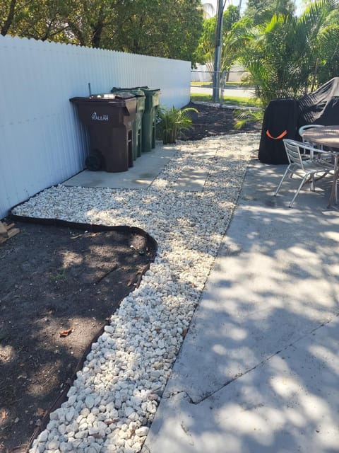White marble chip path curving along a side yard beside the driveway